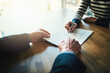 © Lyndon S/peopleimages.com - Going through the terms of their contract. Closeup shot of two unrecognizable businesspeople going through paperwork in an office.