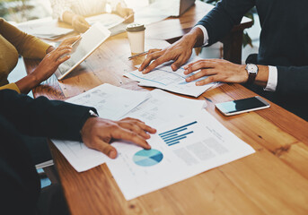 Poster - Lets see what the numbers say. Closeup shot of an unrecognizable group of businesspeople going through paperwork in an office.