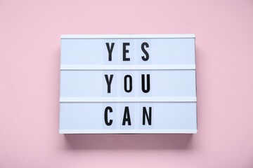 Wall Mural - Lightbox with phrase Yes You Can on pale pink background, top view. Motivational quote