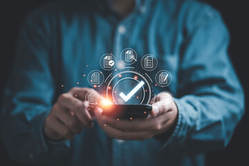 Fototapete - Businessman using smartphone and  virtual correct sign or tick mark with document icon for approve quality assurance and guarantee concept.