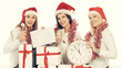 © yurolaitsalbert - closeup.three young women in hats of Santa Claus with Christmas gifts and glasses of champagne .