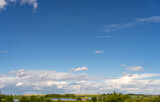 Fototapeta Sawanna - Lots of sky. Landscape overlooking fields, meadows, clouds and a lake.