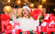 © be free - Our home. christmas blogging. making selfie. happy woman hold phone. xmas morning. party celebration. woman santa hat. happy new year. selfie time. video call to family