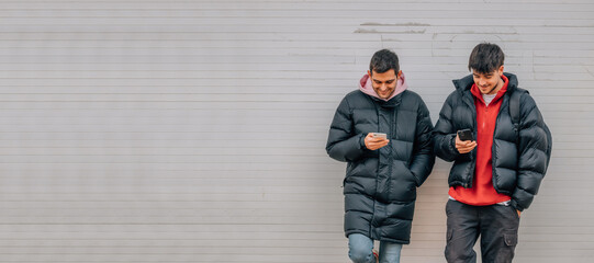 Poster - young people on the street with mobile phone in winter with warm clothes