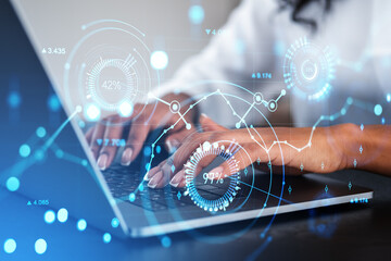 African businesswoman typing on laptop, big business data hologram with lines