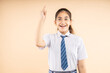 © GAJENDRRA BHATI  - Excited Indian student schoolgirl wearing school uniform having an idea expression with wide open mouth finally found a solution isolated on beige background, Studio shot, closeup, Education concept.