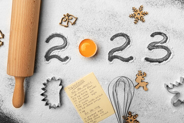 Wall Mural - The inscription 2023 on flour on a kitchen board for working with dough.