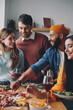 © gstockstudio - Group of young people talking and smiling while enjoying dinner at home together