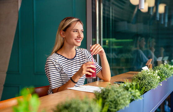 young woman having a good morning healthy smoothie drink made of super foods. people health concept