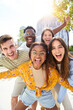 © CarlosBarquero - Vertical photo Happy friends looking at Camera and laughing. Smiling Group of people having fun together outdoors. Cheerful community of students university. Lifestyle of multicultural people joyful.