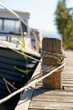 © uladzimirzuyeu - Yacht on a rope at the pier. Sea vessel is moored to an old wooden pier on a sunny summer day.