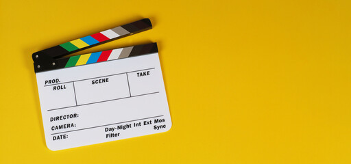 Clapper board or movie slate on yellow background.