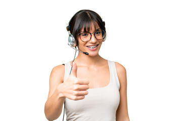 Telemarketer caucasian woman working with a headset over isolated background with thumbs up because something good has happened