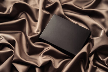 Mockup blank black box on a silk cloth.