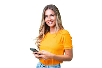 young uruguayan woman over isolated background sending a message with the mobile