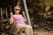 Senior woman joyfully swinging on a swing and having fan. Happy retirement concept