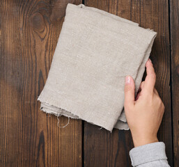 Wall Mural - Gray linen kitchen napkin in a female hand