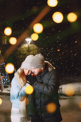 Young couple outdoor in night street at christmas time