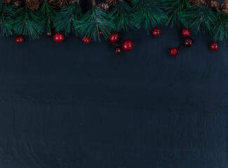 Canvas Print - Border of Christmas fir tip tree branches and red berries on dark stone setting