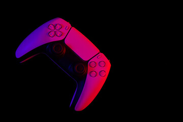 Wall Mural - Modern white gamepad illuminated red and blue on a black background, copy space, game controller for video games.