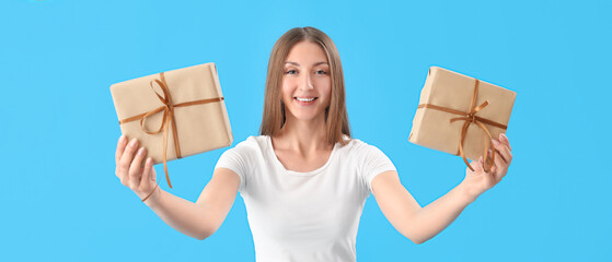 Sticker - Happy young woman with gifts on light blue background