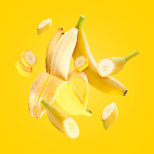 Flying fresh bananas on yellow background