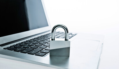 single padlock on laptop keyboard against white background