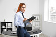 © Pixel-Shot - Beautiful transgender secretary with clipboard in office