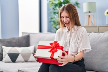 Canvas Print - Beautiful woman holding gift smiling and laughing hard out loud because funny crazy joke.