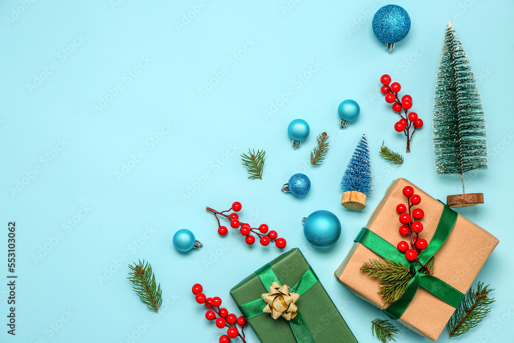 Christmas gift boxes with fir branches and decor on blue background