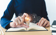 © Koto Amatsukami - Student holding bright lightbulb and reading book or textbook. Success idea of education learning and studying. Businessperson skill training course. Knowledge and cognition concept