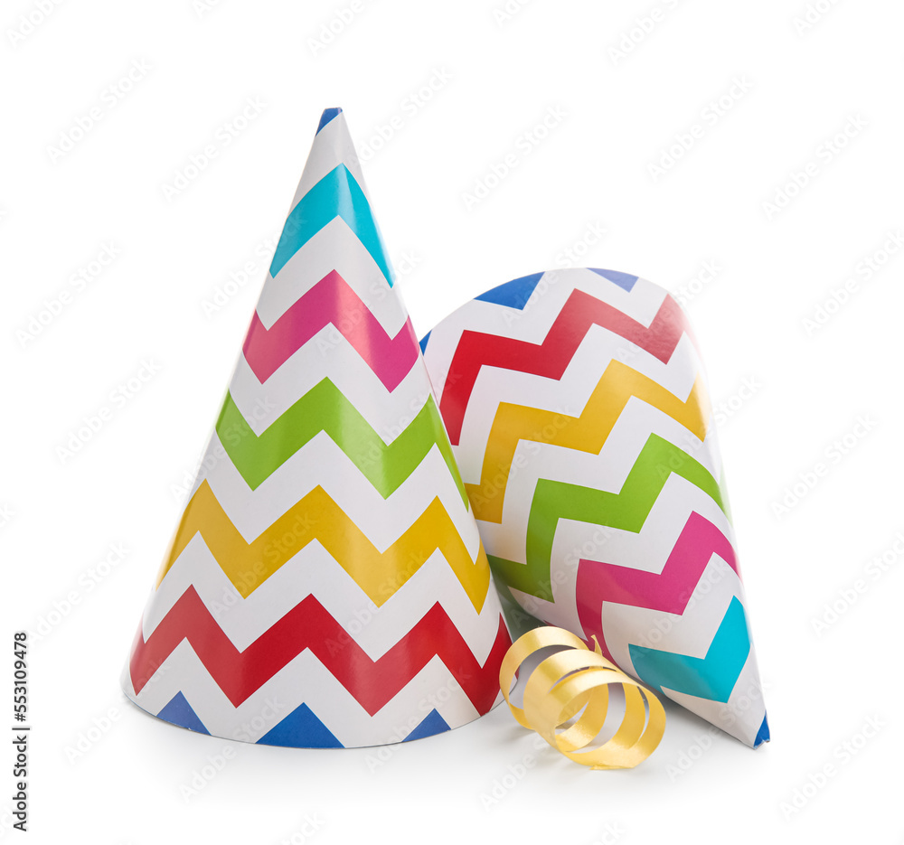 Multicolored party hats with confetti on white background