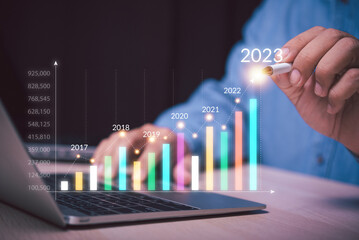 Poster - man hand holding a pen point on growth up business graph to year 2023