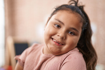 Canvas Print - Plus size hispanic girl student using computer and headphones sitting on table at kindergarten