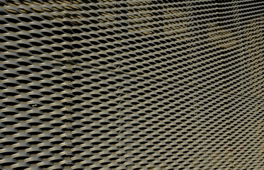 steel cladding of a building with a expanded metal lattice structure. galvanized gray nets protect the industrial building. Blue sky in contrast to a silver background, staircase, laboratory, science