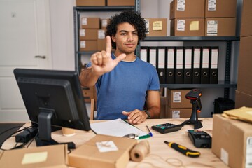 Canvas Print - Hispanic man with curly hair working at small business ecommerce pointing with finger up and angry expression, showing no gesture