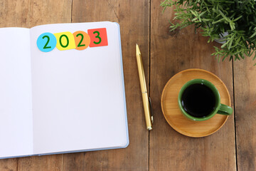 Wall Mural - Business concept of top view 2023 goals with notebook, cup of coffee over wooden desk