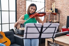 Young Hispanic Woman Musician Playing Violin At Music Studio