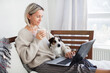 © Tatyana Gladskih - Happy middle aged woman using her laptop on the sofa at home