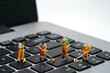 © miniartkur - Miniature people toy figure photography. Group of sweeper workers cleaning notebook laptop keyboard using broom, brush. Isolated on white background