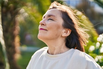 Wall Mural - Middle age woman smiling confident breathing at park