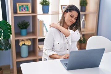 Poster - Young hispanic woman suffering for shoulder pain using laptop at home