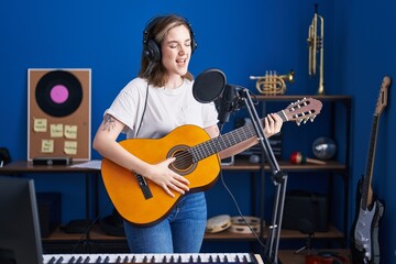 Poster - Young woman musician singing song playing classical guitar at music studio