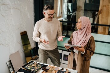 Wall Mural - Two multiracial colleagues designers working together in modern office