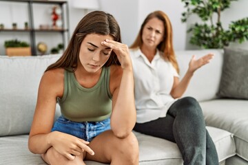 Poster - Mother and daughter unhappy arguing sitting on sofa at home