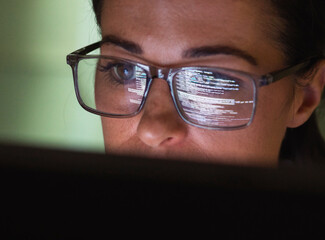 Computer programmer wearing eyeglasses looking at codes