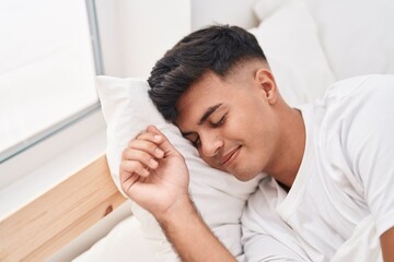 Poster - Young hispanic man lying on bed sleeping at bedroom