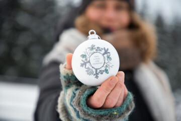 Sticker - woman holding Christmas decoration in snow