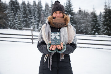 Sticker - woman holding Christmas decoration in snow