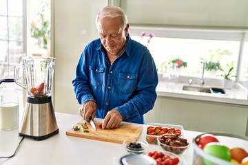 Poster - Senior man smiling confident cutting datil at kitchen